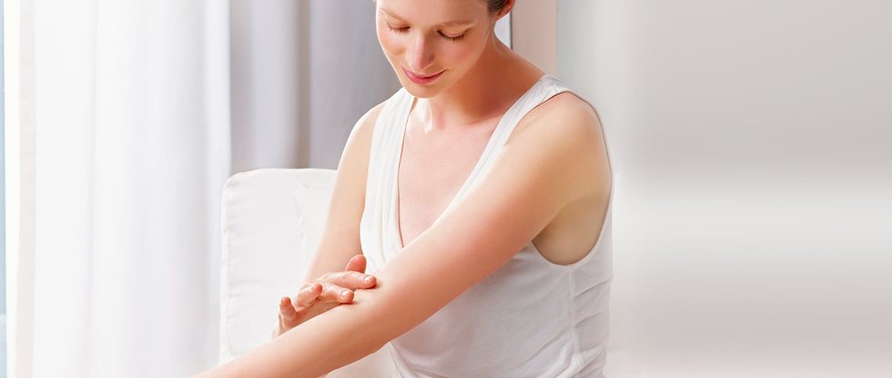 Frau berührt ihren Arm