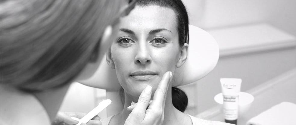 Frau wird im Gesicht mit einem Eucerin Produkt behandelt