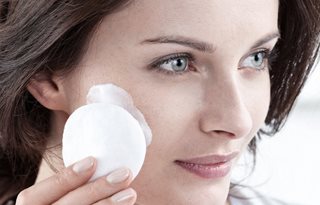 Frau reinigt ihr Gesicht