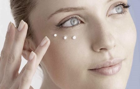 Frau trägt Eucerin Hyal-Urea Anti-Falten Augencreme auf.