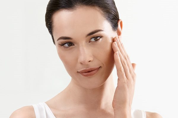 Frau trägt Konzentrat zwischen den Augen auf.