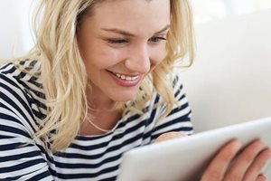 Lachende Frau mit Tablett in der Hand